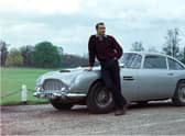 Edinburgh-born actor Sean Connery poses beside the Aston Martin DB5 in a publicity shot for the James Bond film Goldfinger.