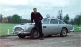 Edinburgh-born actor Sean Connery poses beside the Aston Martin DB5 in a publicity shot for the James Bond film Goldfinger.
