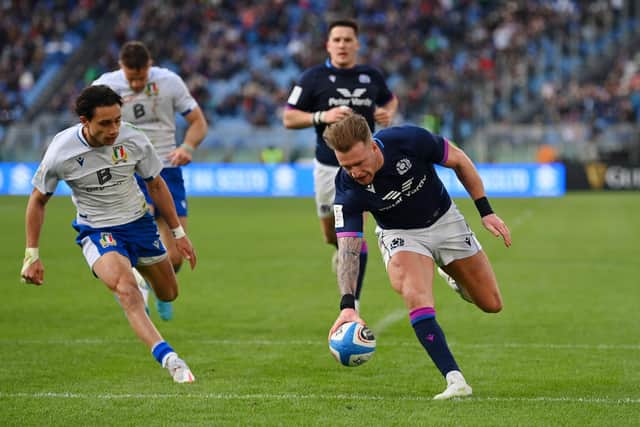 Stuart Hogg of Scotland touches down for their fifth try before Ange Capuozzo of Italy during the Guinness Six Nations Rugby match between Italy and Scotland at Stadio Olimpico.