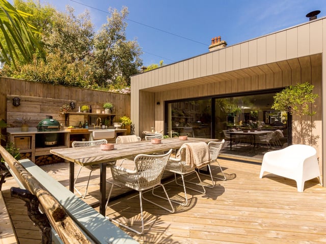 Exterior: Wooden terraces with outdoor kitchen, two guest bedroom suites at the end of the garden.