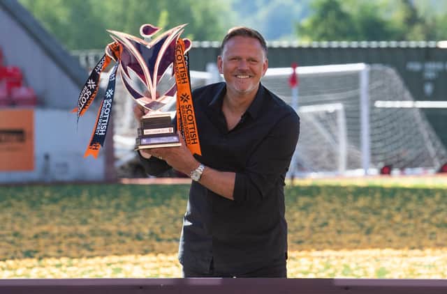 Scott Booth celebrates with the SWPL trophy after leading Glasgow City to the title earlier this year