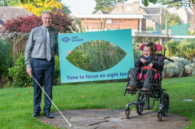 Gavin Jarron, a member of staff at the Royal Blind School and Lolly, a pupil at the school, showing the new name of the charity.