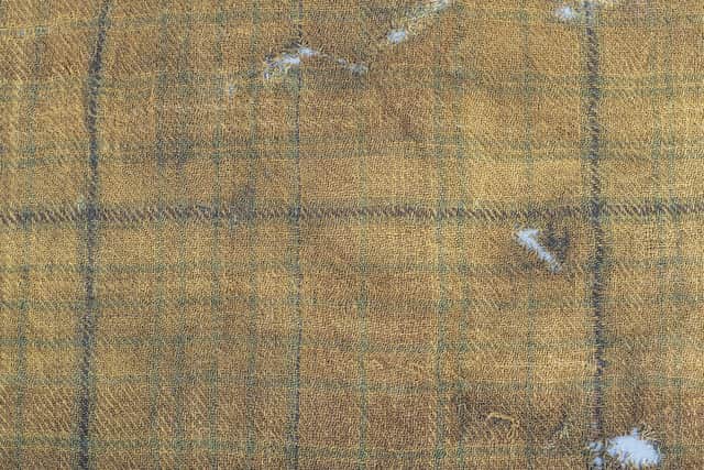 John McLeish, chair of the Scottish Tartans authority, V&A Dundee curator James Wylie and tartan historian Peter MacDonald have a close look at the Glen Affric tartan. Picture: Alan Richardson