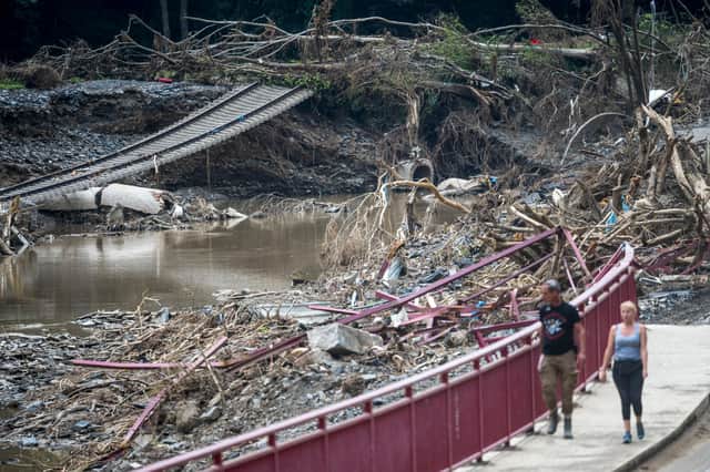 People walk past railway tracks destroyed by flash floods in the Ahr Valley (Picture: Thomas Lohnes/Getty Images)