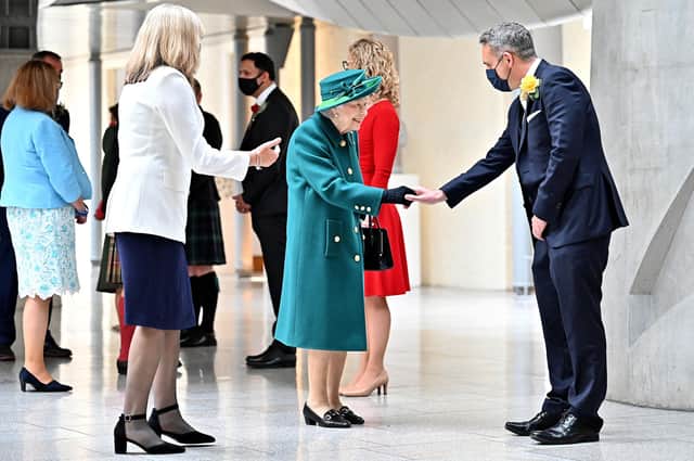Queen Elizabeth shakes hands with Scottish Liberal Democrat leader and Evening News columnist Alex Cole-Hamilton on her arrival for the opening of the Scottish Parliament (Picture: Jeff J Mitchell/pool/AFP via Getty Images)