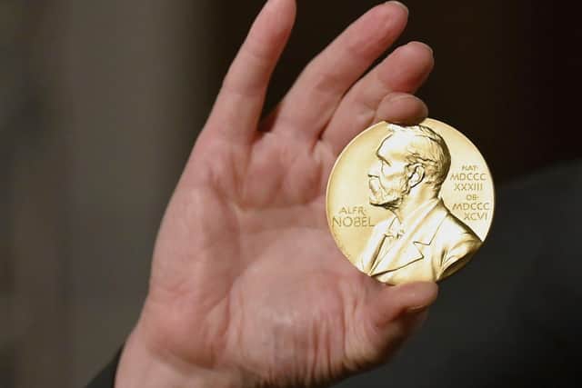 A Nobel medal is held up during a ceremony in New York.  (Angela Weiss/Pool Photo via AP, File)