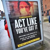 Members of the public walk past a government poster reminding people to socially distance and abide by the lockdown restrictions in the city centre on January 29, 2021 in Glasgow. Photo by Jeff J Mitchell/Getty Images