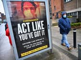 Members of the public walk past a government poster reminding people to socially distance and abide by the lockdown restrictions in the city centre on January 29, 2021 in Glasgow. Photo by Jeff J Mitchell/Getty Images