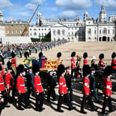 The coffin of Queen Elizabeth II, draped in the Royal Standard with the Imperial State Crown placed on top, is carried on a horse-drawn gun carriage of the King's Troop Royal Horse Artillery, during the ceremonial procession from Buckingham Palace to Westminster Hall, London.