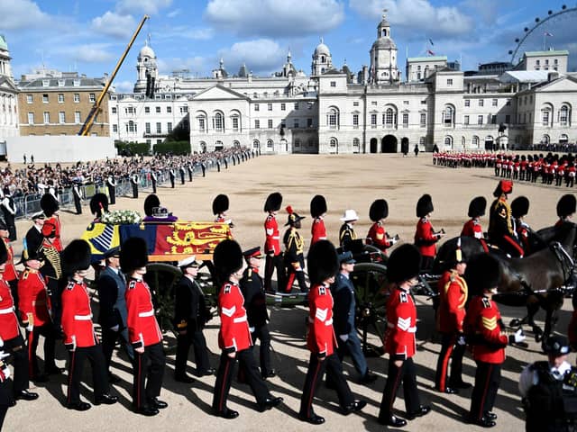 The coffin of Queen Elizabeth II, draped in the Royal Standard with the Imperial State Crown placed on top, is carried on a horse-drawn gun carriage of the King's Troop Royal Horse Artillery, during the ceremonial procession from Buckingham Palace to Westminster Hall, London.