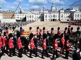 The coffin of Queen Elizabeth II, draped in the Royal Standard with the Imperial State Crown placed on top, is carried on a horse-drawn gun carriage of the King's Troop Royal Horse Artillery, during the ceremonial procession from Buckingham Palace to Westminster Hall, London.