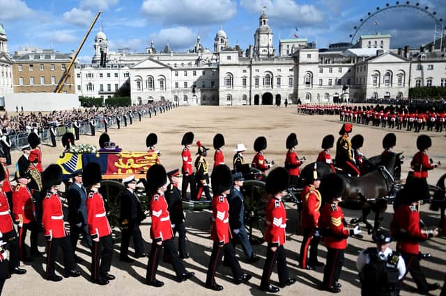 The coffin of Queen Elizabeth II, draped in the Royal Standard with the Imperial State Crown placed on top, is carried on a horse-drawn gun carriage of the King's Troop Royal Horse Artillery, during the ceremonial procession from Buckingham Palace to Westminster Hall, London.