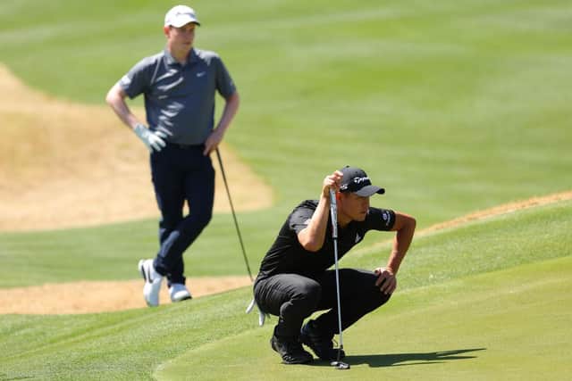Bob MacIntyre looks on as Collin Morikawa lines up a putt during their opening-day tie in the WGC-Dell Technologies Match Play at Austin Country Club in Austin, Texas. Picture: Kevin C. Cox/Getty Images.