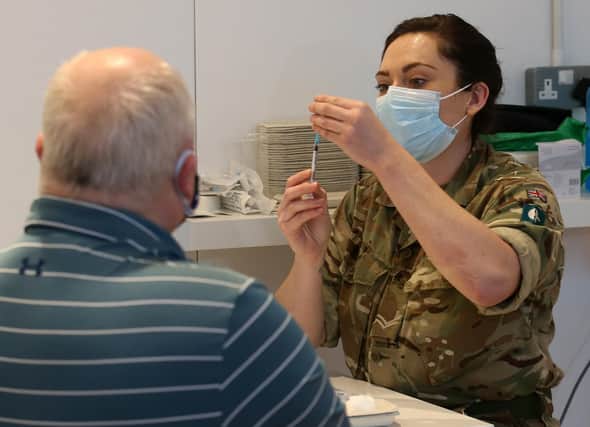 James Logan from Edinburgh, receives an injection of a coronavirus vaccine from military personnel who are assisting with the vaccination programme at the Royal Highland Showground near Edinburgh. Picture date: Thursday February 4, 2021.