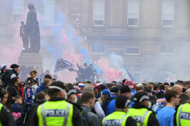 Police officers monitor as Rangers fans celebrate in George Square in Glasgow on May 15, 2021. (Photo by ANDY BUCHANAN/AFP via Getty Images)