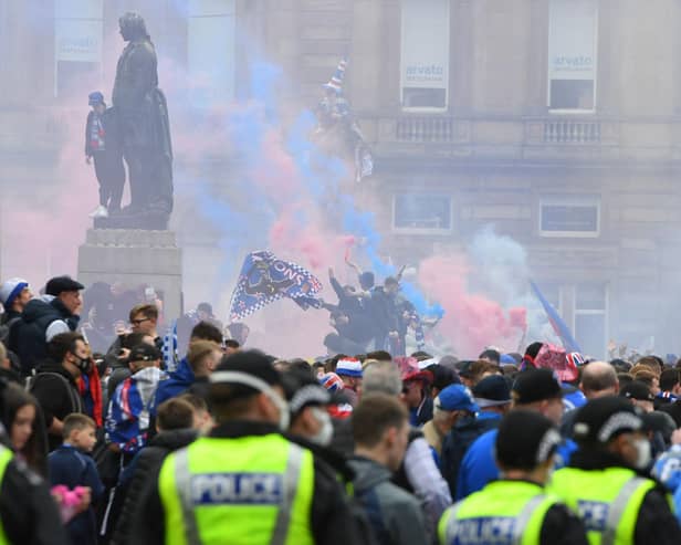 Police officers monitor as Rangers fans celebrate in George Square in Glasgow on May 15, 2021. (Photo by ANDY BUCHANAN/AFP via Getty Images)