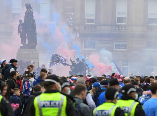 Police officers monitor as Rangers fans celebrate in George Square in Glasgow on May 15, 2021. (Photo by ANDY BUCHANAN/AFP via Getty Images)