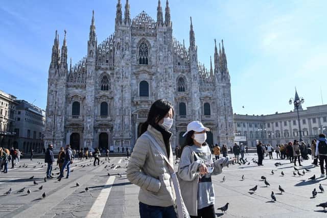 Two women wearing protective facemasks walk across the Piazza del Duomo in central Milan (Photo: ANDREAS SOLARO/AFP via Getty Images)