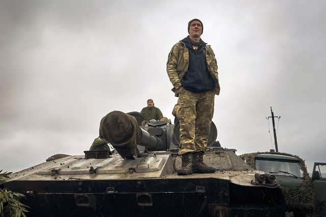 A Ukrainian soldier stands on a tank on the road in the freed territory of the Kharkiv region, Ukraine, AP Photo/Kostiantyn Liberov