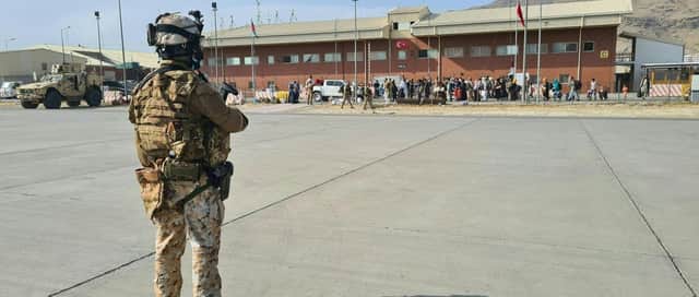 Soldiers on the tarmac waiting for passengers, who fled Afghanistan, to board on an Italian military aircraft at Kabul airport.