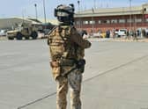 Soldiers on the tarmac waiting for passengers, who fled Afghanistan, to board on an Italian military aircraft at Kabul airport.