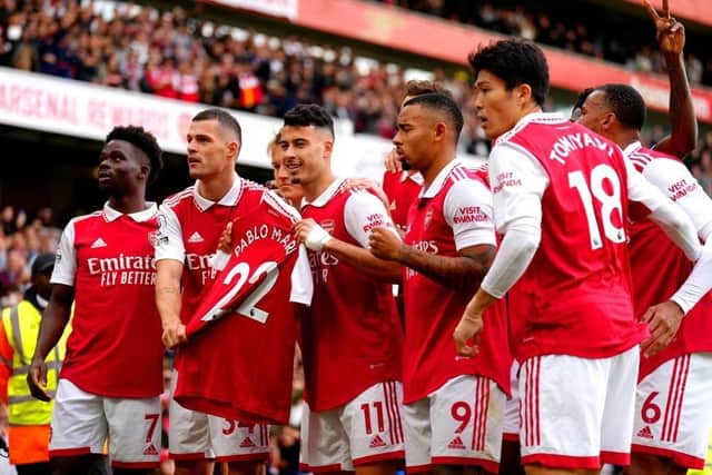 Arsenal's Gabriel Martinelli (centre) holds up former team-mate Pablo Mari's shirt as he celebrates scoring their side's first goal of the game during the Premier League match at the Emirates Stadium,