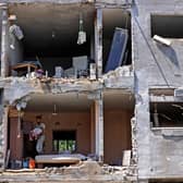 Palestinians assess the damage in a building caused by Israeli air strikes, in Beit Hanun in the northern Gaza Strip, on May 14, 2021. - Israel pounded Gaza and deployed extra troops to the border as Palestinians fired barrages of rockets back, with the death toll in the enclave on the fourth day of conflict climbing to over 100. (Photo by MAHMUD HAMS / AFP) (Photo by MAHMUD HAMS/AFP via Getty Images)