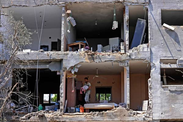 Palestinians assess the damage in a building caused by Israeli air strikes, in Beit Hanun in the northern Gaza Strip, on May 14, 2021. - Israel pounded Gaza and deployed extra troops to the border as Palestinians fired barrages of rockets back, with the death toll in the enclave on the fourth day of conflict climbing to over 100. (Photo by MAHMUD HAMS / AFP) (Photo by MAHMUD HAMS/AFP via Getty Images)