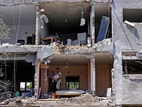 Palestinians assess the damage in a building caused by Israeli air strikes, in Beit Hanun in the northern Gaza Strip, on May 14, 2021. - Israel pounded Gaza and deployed extra troops to the border as Palestinians fired barrages of rockets back, with the death toll in the enclave on the fourth day of conflict climbing to over 100. (Photo by MAHMUD HAMS / AFP) (Photo by MAHMUD HAMS/AFP via Getty Images)