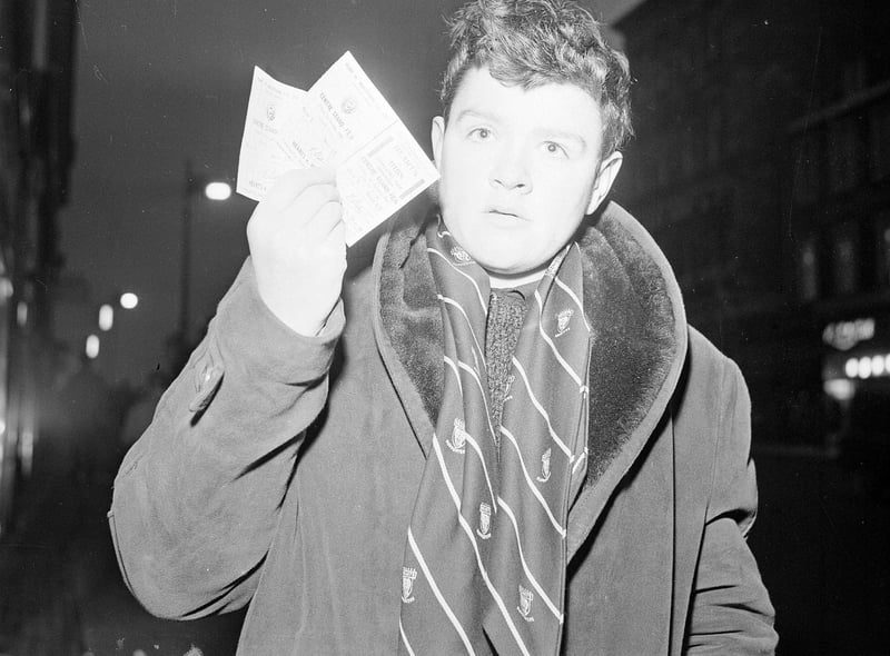 Wearing his official Hearts Supporter scarf, Alex Spence clutches his two tickets for the Hearts v Hibs Edinburgh derby match to be played at Tynecastle on New Year's Day 1965.