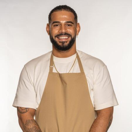 Sandro was born in Angola, but fled the Angolan war with his mum when he was two, settling then in London. Passionate about fitness, Sandro is a keen boxer and has a background in ballet and breakdance too! When Sandro was 21 his father passed away and he turned to baking as a form of therapy. Now, he lives and breathes it, and is often found rustling up bakes in a relaxed vibe with the telly on, or running virtual baking classes for children with autism. He likes to infuse his bakes with flavours from his Angolan heritage – the spice of paprika paired with tangy cheese, and sweet bakes smothered in sticky dulce de leche.