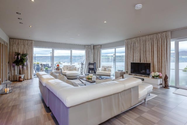 The main lounge includes a freestanding wood burning stove and full-height picture glazing to two aspects, each incorporating patio doors to the terrace.