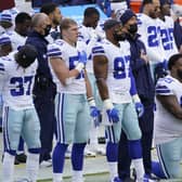 Members of the Dallas Cowboys on the sidelines during playing of the National Anthem before the start of an NFL game on Sunday