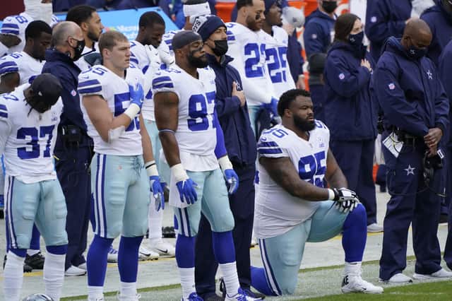 Members of the Dallas Cowboys on the sidelines during playing of the National Anthem before the start of an NFL game on Sunday