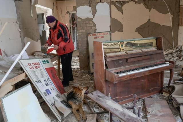 A man collects pictures from a school hit by Russian rockets in the southern Ukraine village of Zelenyi Hai between Kherson and Mykolaiv, earlier this month.