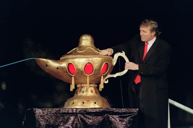 In 1990, the then real estate developer Donald Trump rubs a "magic lamp" during the opening ceremony for his Taj Mahal casino in Atlantic city (Picture: Bill Swersey/AFP via Getty Images)