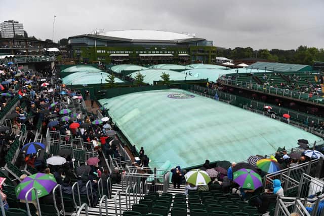 General view across the outside courts as rain covers are seen and spectators shelter under umbrellas during Day One of The Championships - Wimbledon 2021. (Photo by Mike Hewitt/Getty Images)