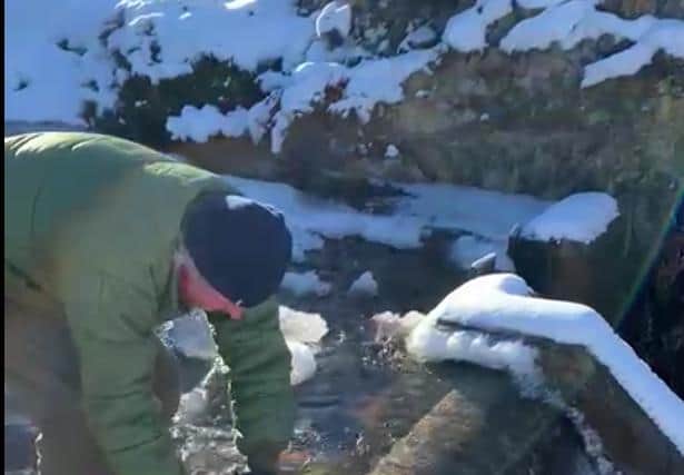 Simon Blackett breaking ice at the community's hydro electric scheme to help water flow picture: supplied