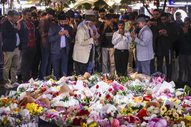 Members of the Ahmadiyya Muslim Community of Australia offer prayers in front of flowers left outside the Westfield Bondi Junction shopping mall in Sydney. Picture: David Gray/AFP via Getty Images