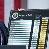 President Donald Trump holds up a chart while speaking during a “Make America Wealthy Again” trade announcement event in the Rose Garden 