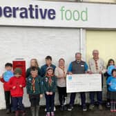 Braemar Co-op Store Manager, Chris Booth with the leaders and members of Braemar 1st Scouts group.