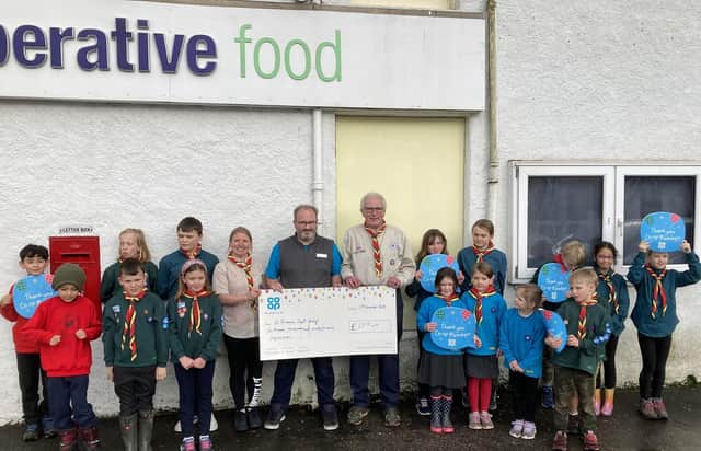 Braemar Co-op Store Manager, Chris Booth with the leaders and members of Braemar 1st Scouts group.
