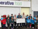Braemar Co-op Store Manager, Chris Booth with the leaders and members of Braemar 1st Scouts group.
