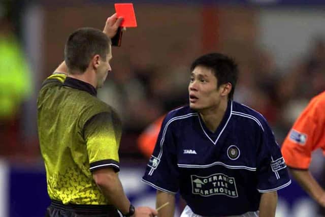 Dundee' debutant Fan Zhiyi is sent off by referee Stuart Dougal for a second bookable offence - diving.