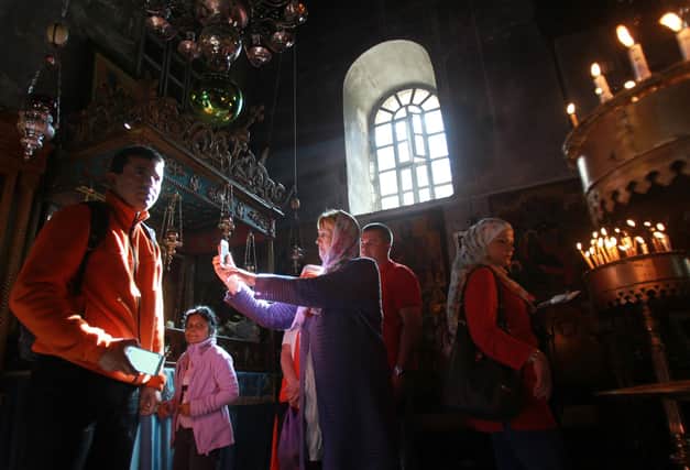 Christian worshipers take photographs inside the Church of the Nativity, believed to be the birthplace of Jesus Christ, in the West Bank town of Bethlehem (Picture: Musa al-Shaer/AFP via Getty Images)