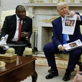 President Donald Trump holds up a printed article from "American Thinker" while accusing South Africa President Cyril Ramaphosa of state-sanctioned violence against white farmers in South Africa during a press availability in the Oval Office at the White House on May 21