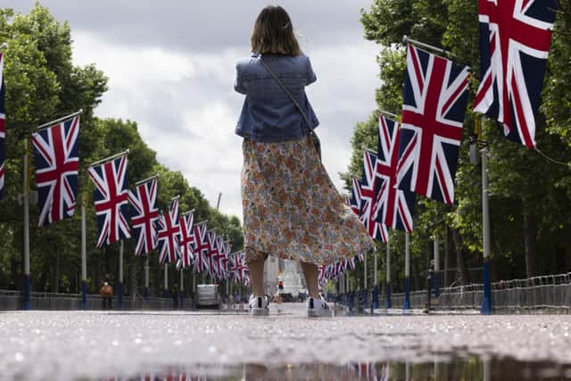 A member of the public takes a photograph on the Mall which has been lined with Union Flags in preparation for the Queen's Jubilee