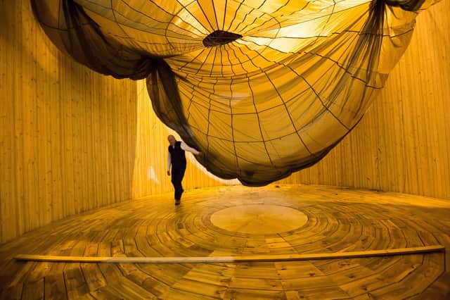 Volunteer PK in the Wall of Death removing a parachute that was draped over the structure. PIC: Robert Perry.