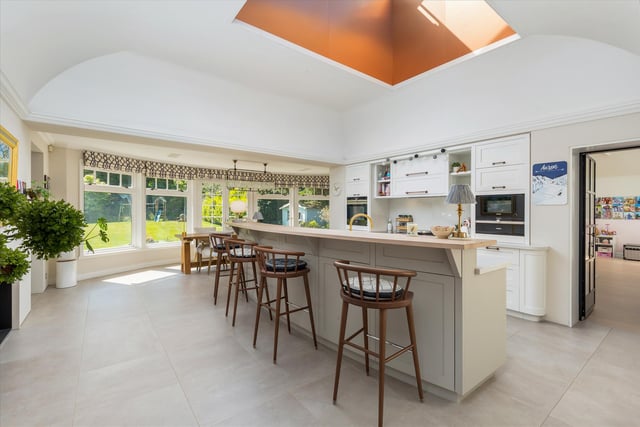 The kitchen is by Laurence McIntosh, with a delightful fan-shaped breakfast bar and solid wood units with white stone worktops.