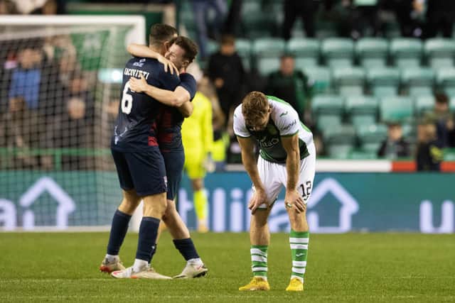 Hibs midfielder Chris Cadden is dejected as Ross County goalscorers Alex Iacovitti and Goerge Harmon celebrate at full-time. (Photo by Ross Parker / SNS Group)